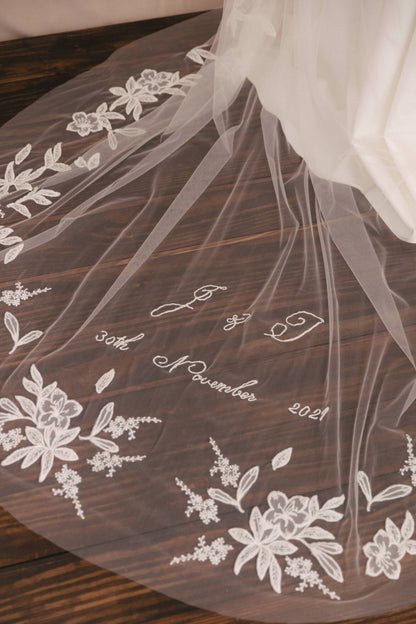 Veil with floral embroidery and text on a wooden surface