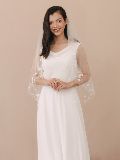 Woman wearing a white wedding dress with a sheer overlay on a beige background