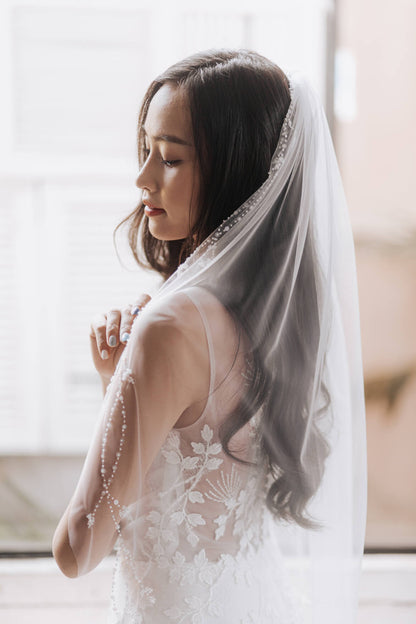 Woman wearing a white wedding dress with a veil indoors