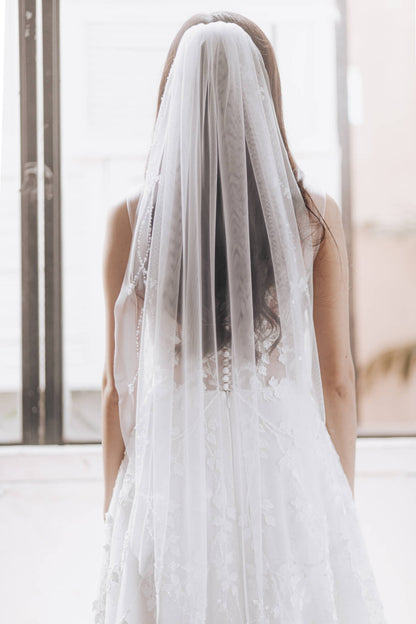 Person wearing a long white veil in an indoor setting