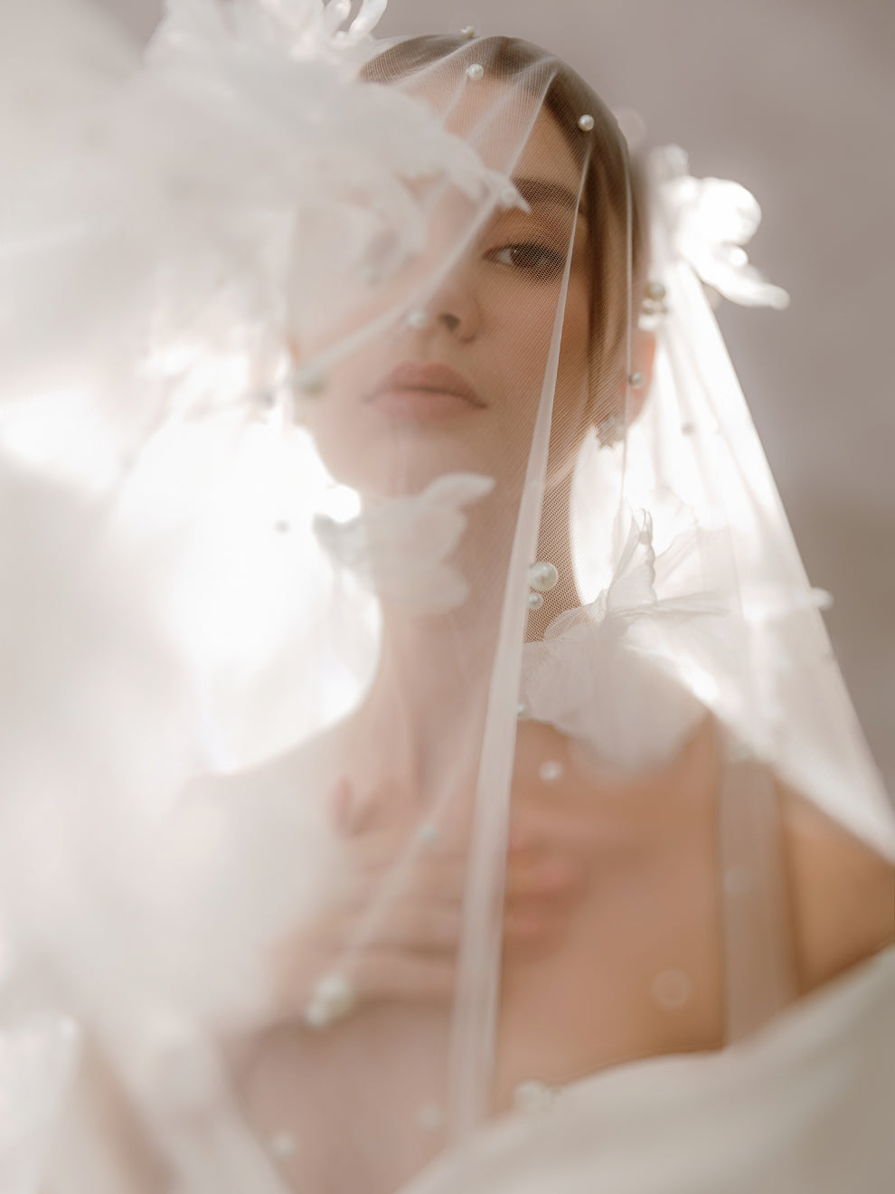 Woman wearing a white wedding dress with a veil and floral headpiece.