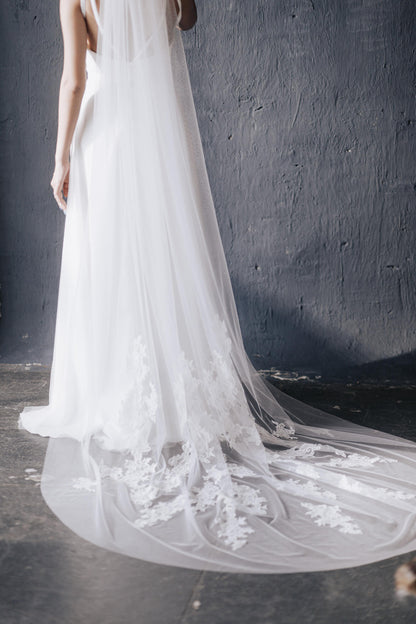 White wedding dress with a long train against a dark background