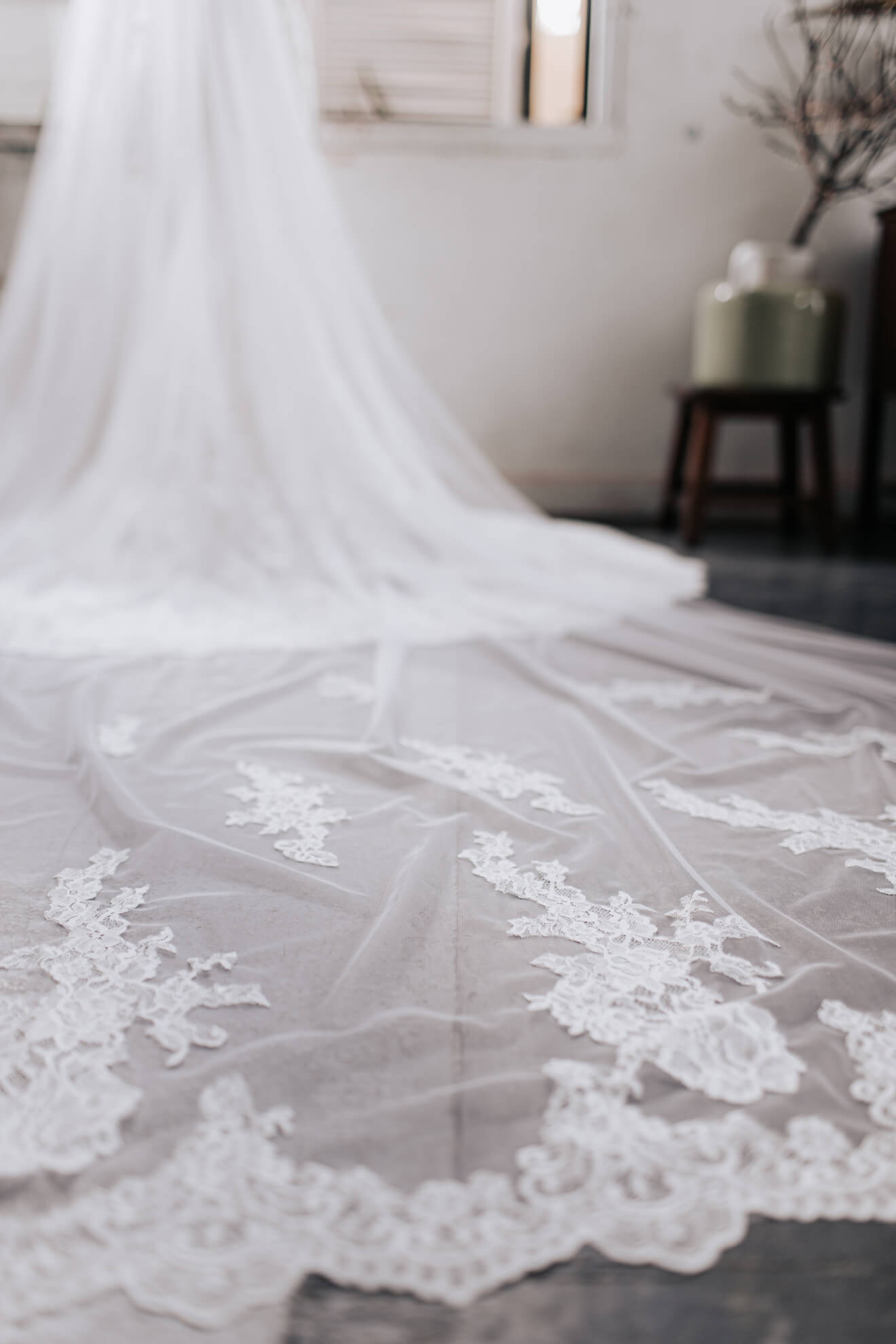 Close-up of a white lace fabric with intricate patterns on a neutral background