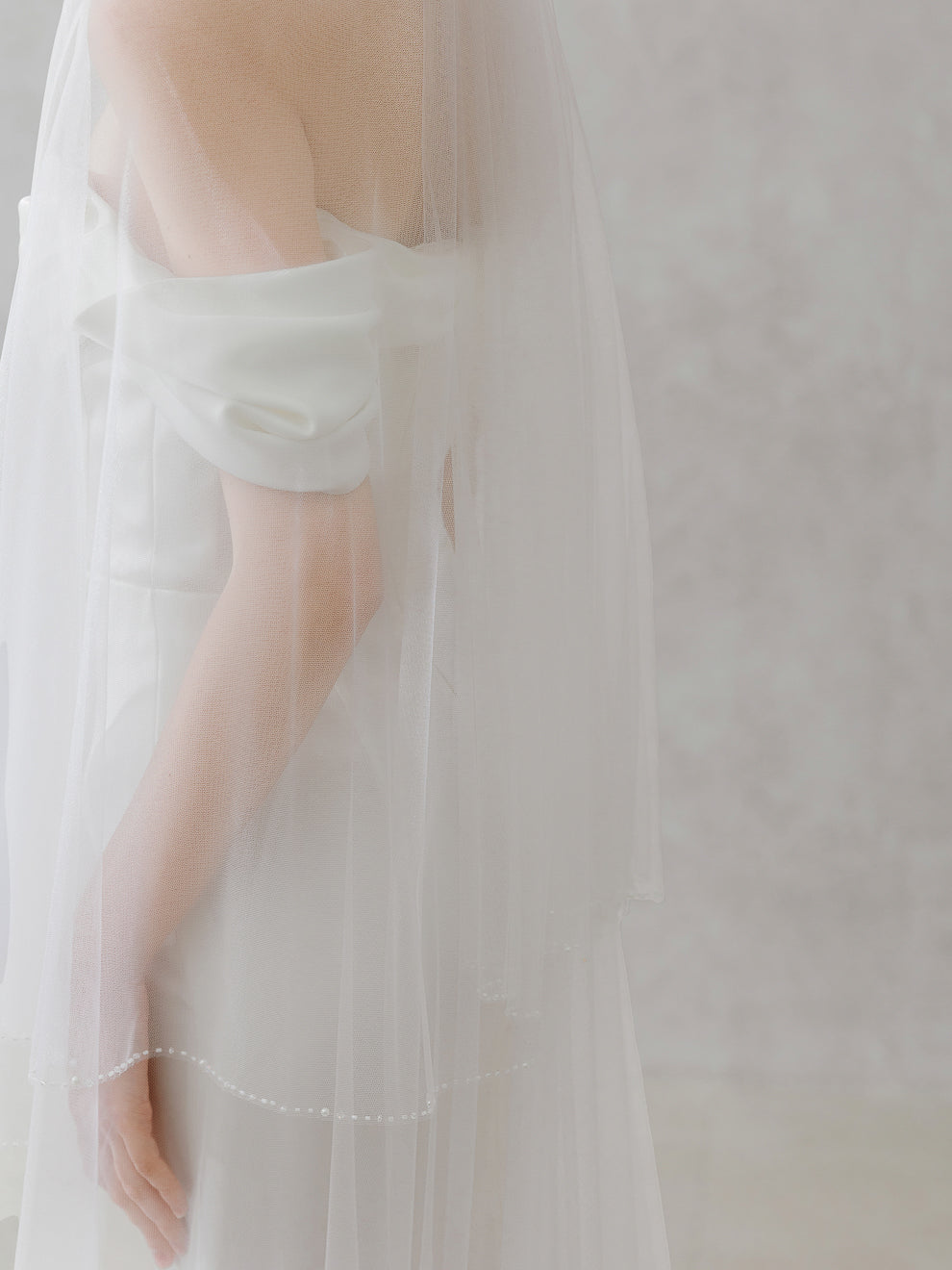 Light green off-shoulder top worn by a person with a blurred background