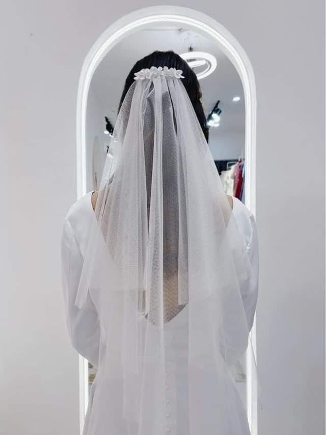 Back view of a bride wearing the Graceful Sheer Two-Tier Veil with a delicate floral comb.