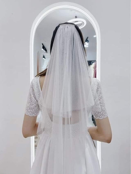 Bride wearing a Delicate Double-Layer Veil with subtle sparkle, standing in front of a mirror.