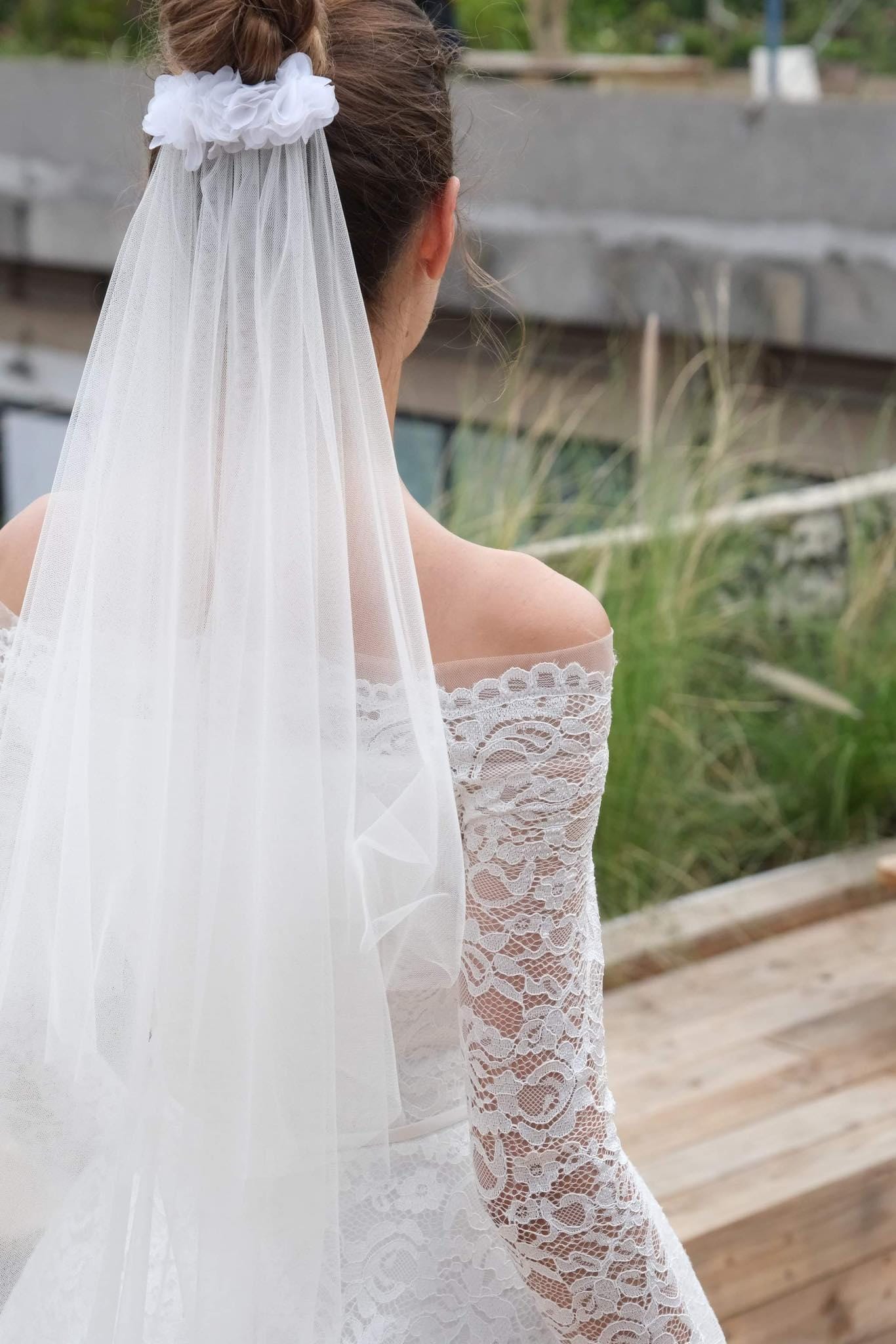 Bride wearing a Romantic Floral Accent Veil with soft tulle and delicate floral accents, paired with an off-the-shoulder lace gown.