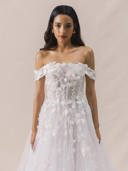 Woman wearing a white off-shoulder floral dress against a beige background