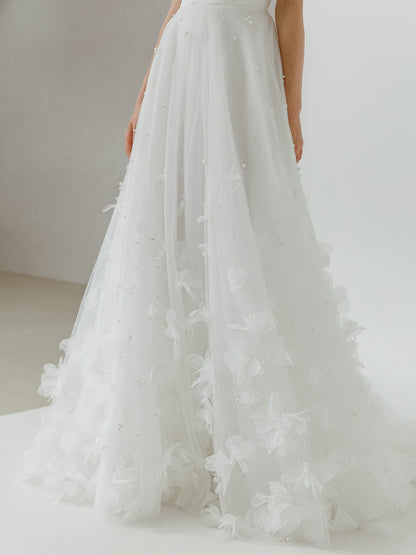 White wedding dress with floral details on a plain background