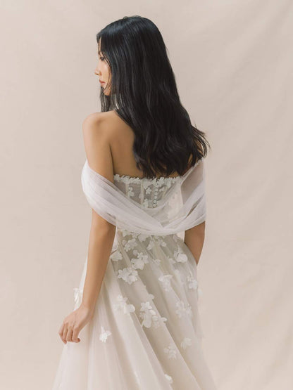 Woman wearing a floral off-shoulder dress against a beige background