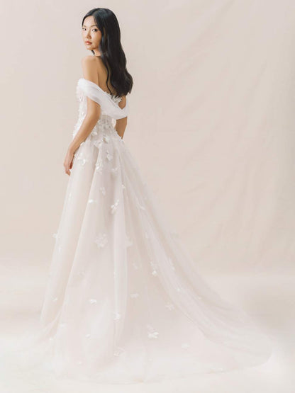 Woman wearing a white wedding dress against a plain background