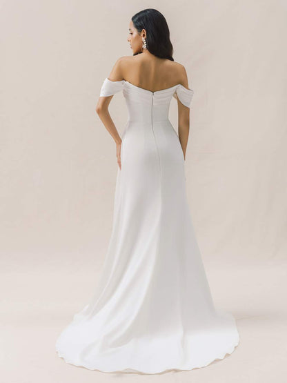 Woman wearing a white off-shoulder wedding dress on a beige background