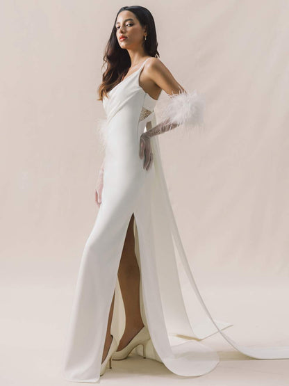 Woman in a white gown with a high slit on a plain background