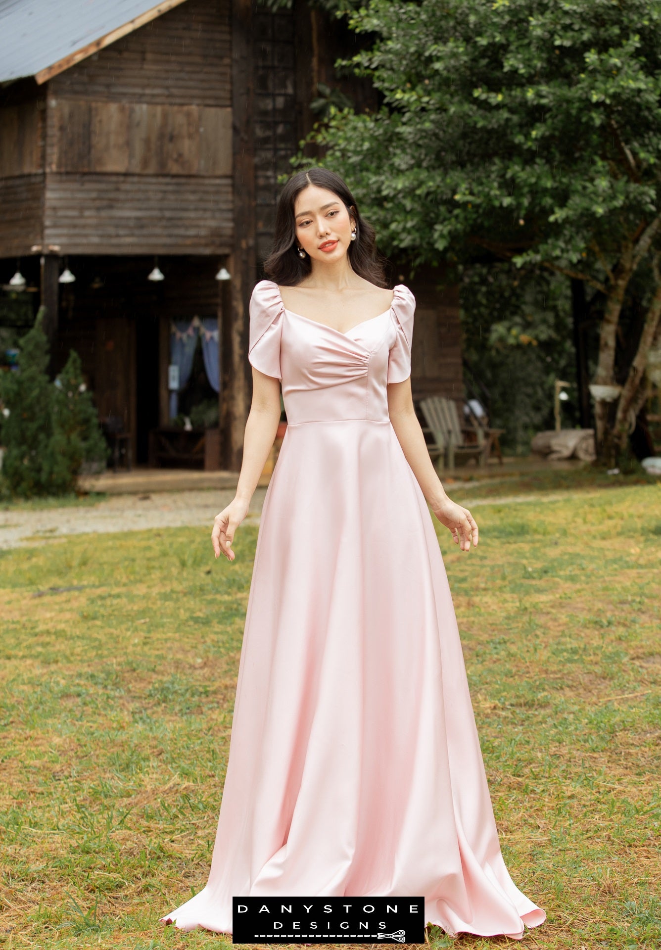 Woman in a pink dress with short sleeves and pleated front panels