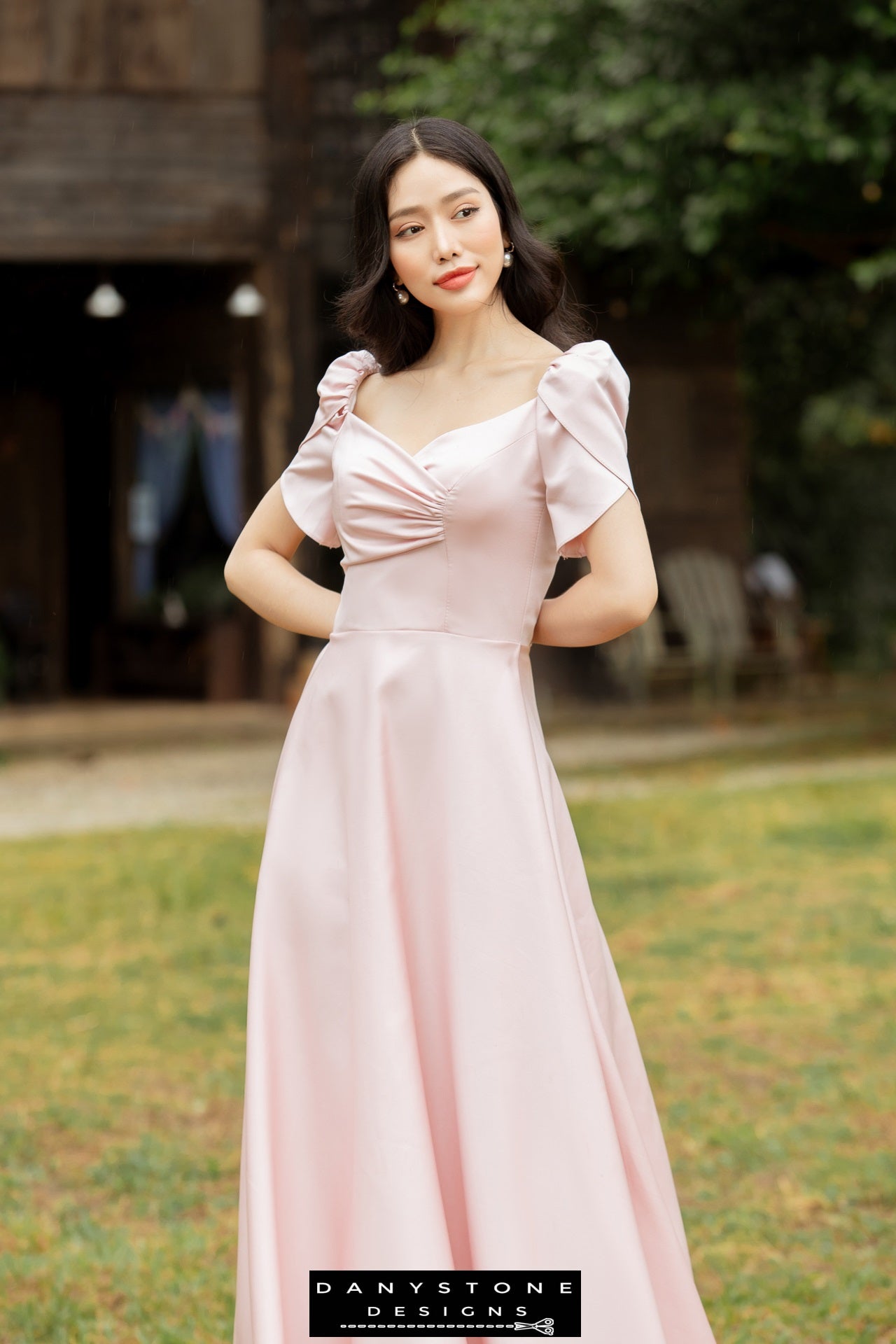 Model showcasing a pink short-sleeved dress with pleated front panels