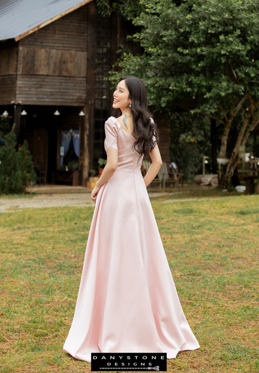 Model wearing an elegant pink short-sleeved dress with pleated front panels