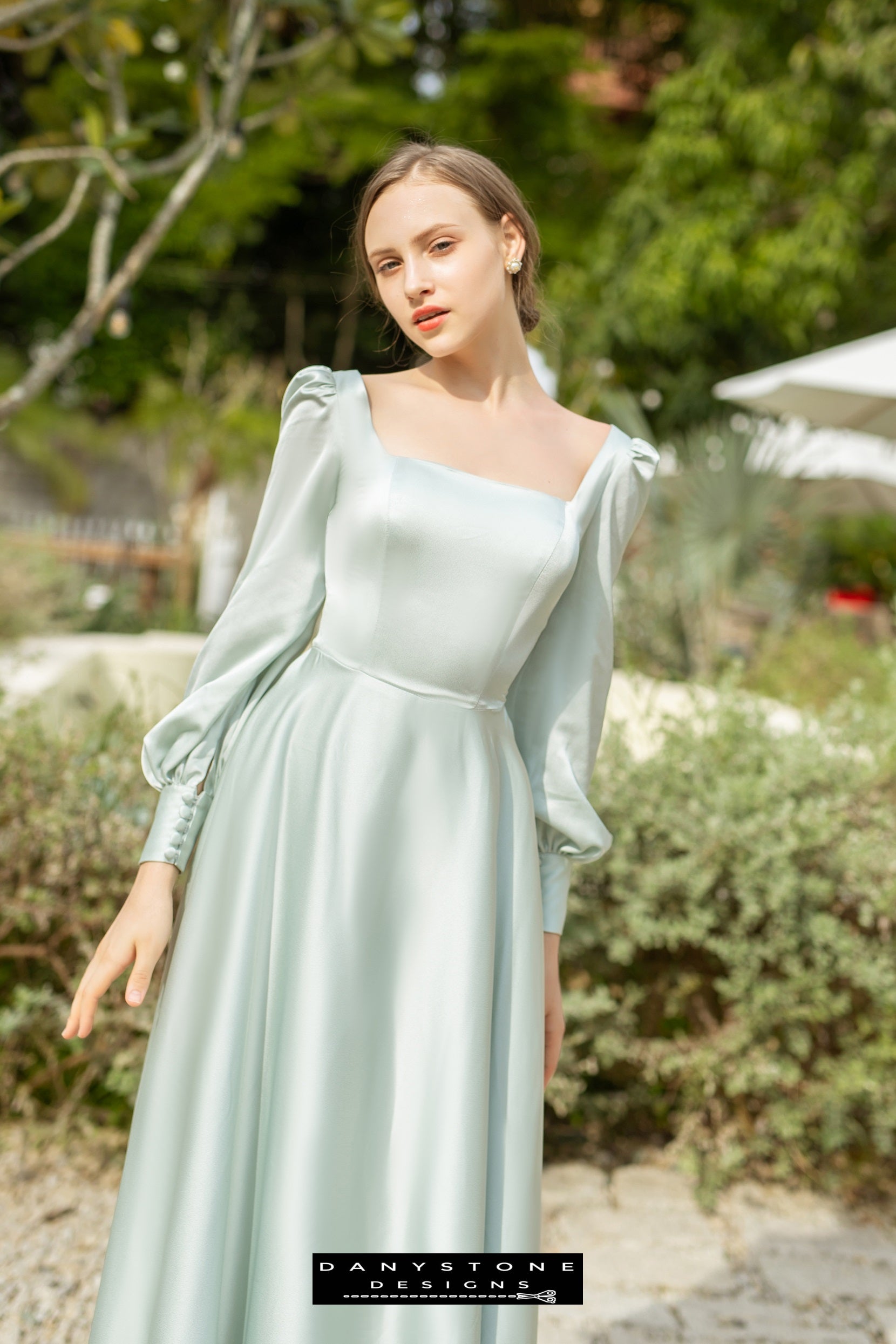 Olive square neck silk dress with long sleeves modeled outdoors