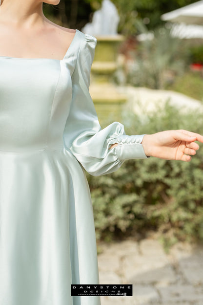 Elegant olive long-sleeved dress with a square neckline in a garden