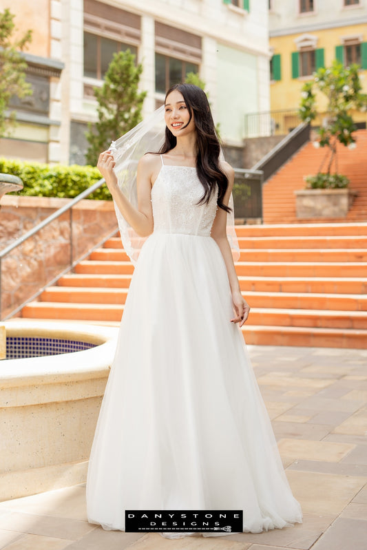 Image 1: Bride wearing a camisole wedding dress with mesh beads, standing on outdoor steps.