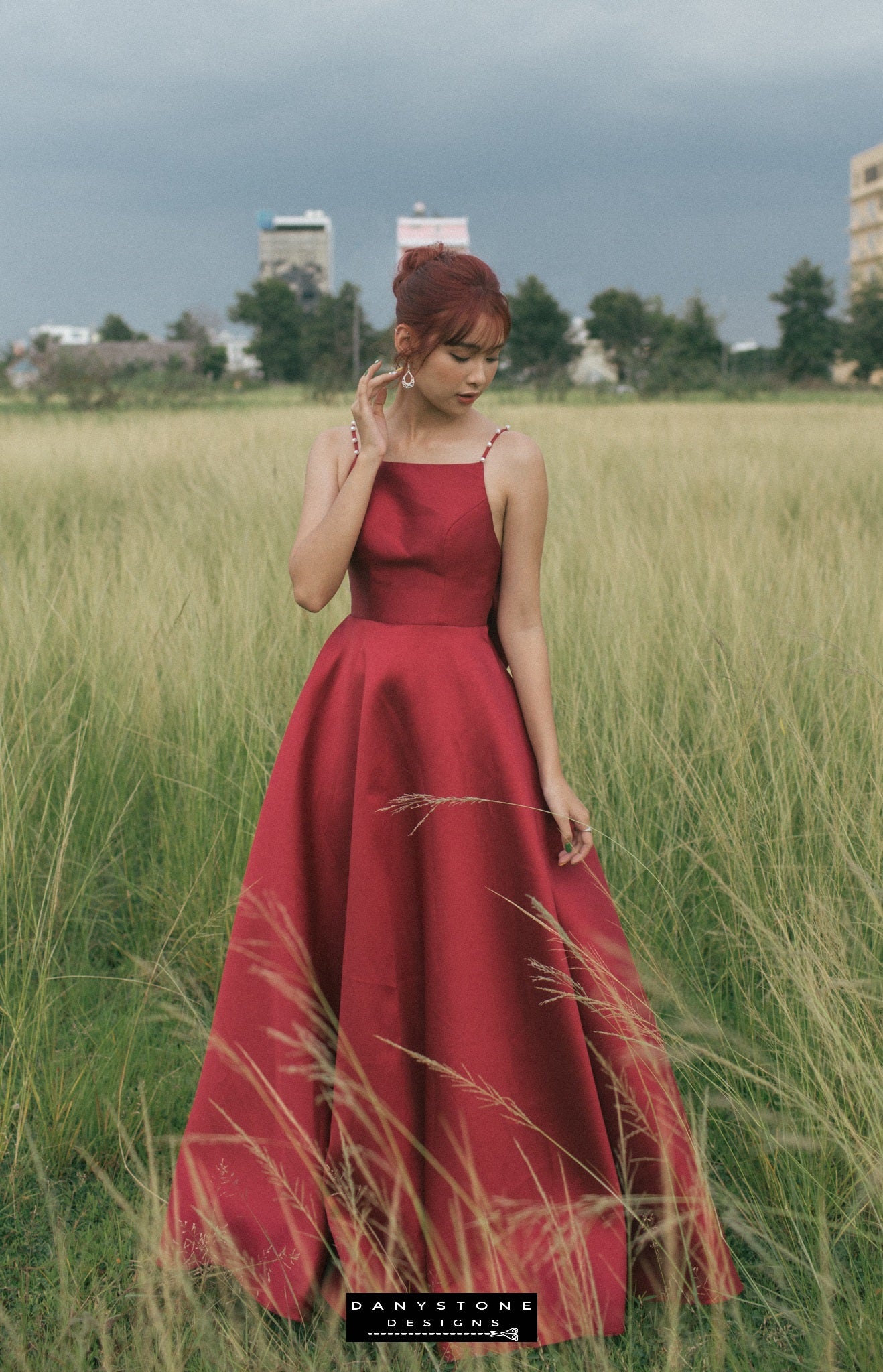 Red evening gown with a dramatic back bow and pearl detailing seen from behind