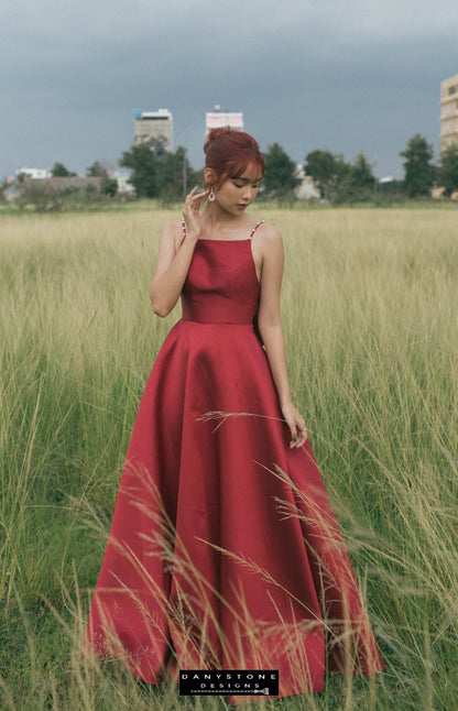 Red evening gown with a dramatic back bow and pearl detailing seen from behind