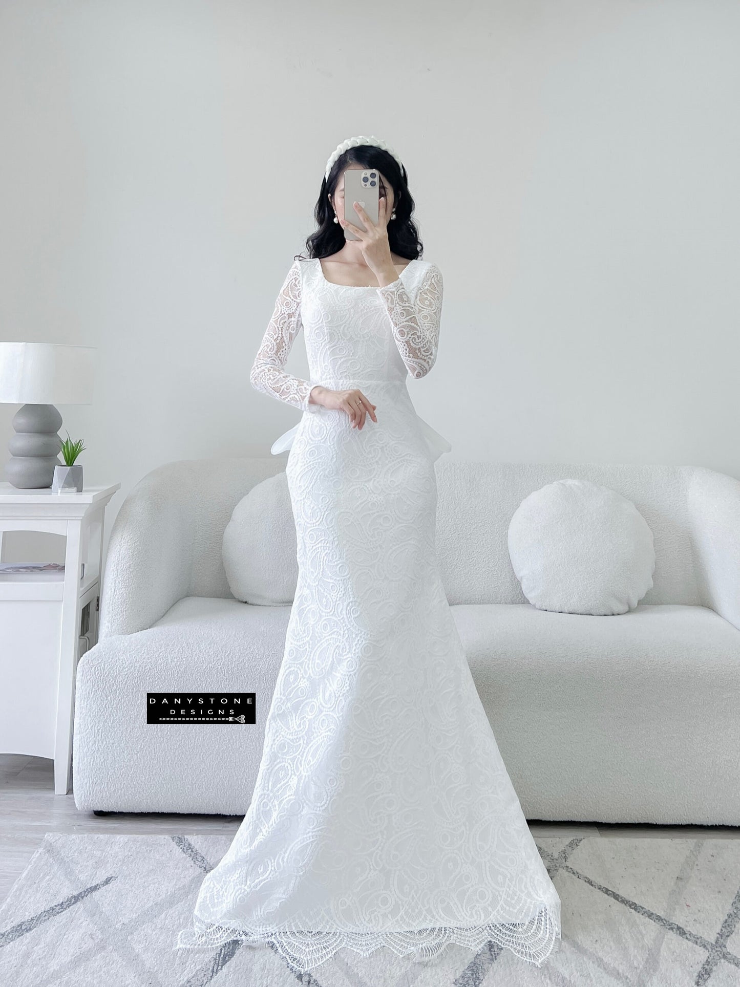 Bride in lace fishtail dress with full U back and silk chiffon bow, front view.