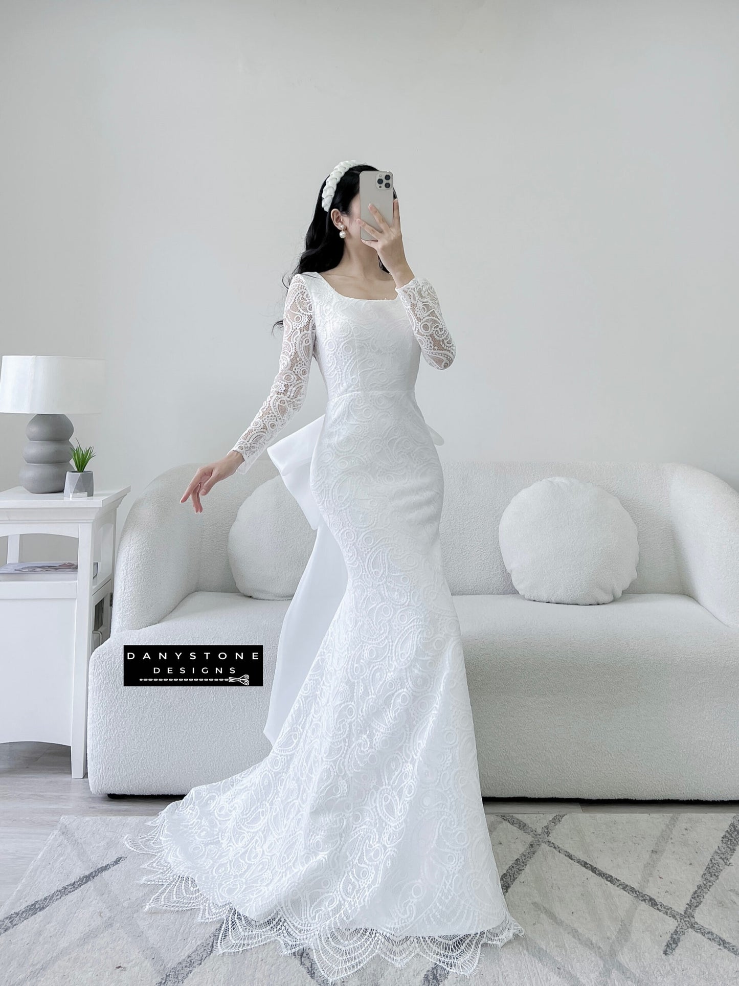 Bride in lace fishtail dress with full U back and silk chiffon bow, side view.