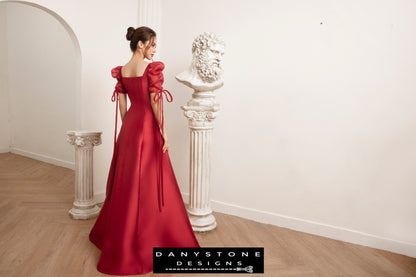 Model showcasing a luxurious red wedding dress with silk chiffon sleeves by Danystone Designs