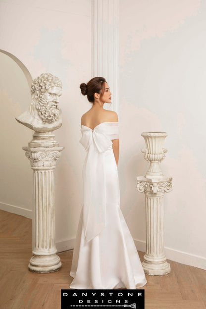 Bride in fishtail wedding dress with flat shoulders and silk chiffon trim, back view showing the chiffon trim bow.