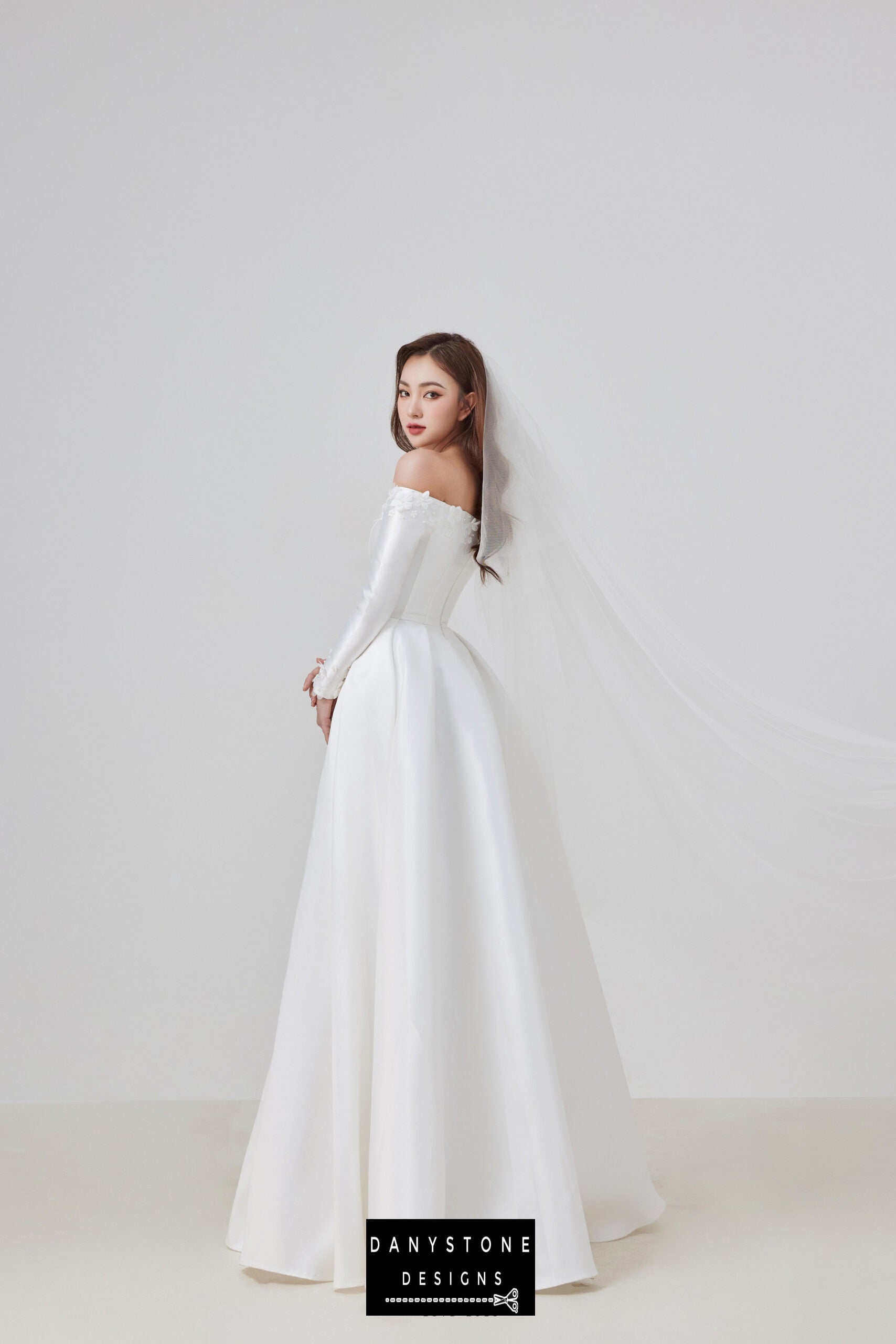 Elevate your bridal look with this exquisite off-shoulder taffeta wedding dress. The sophisticated design features a flat shoulder neckline and intricate 3D floral appliqués, perfect for the modern bride who seeks elegance and sophistication.