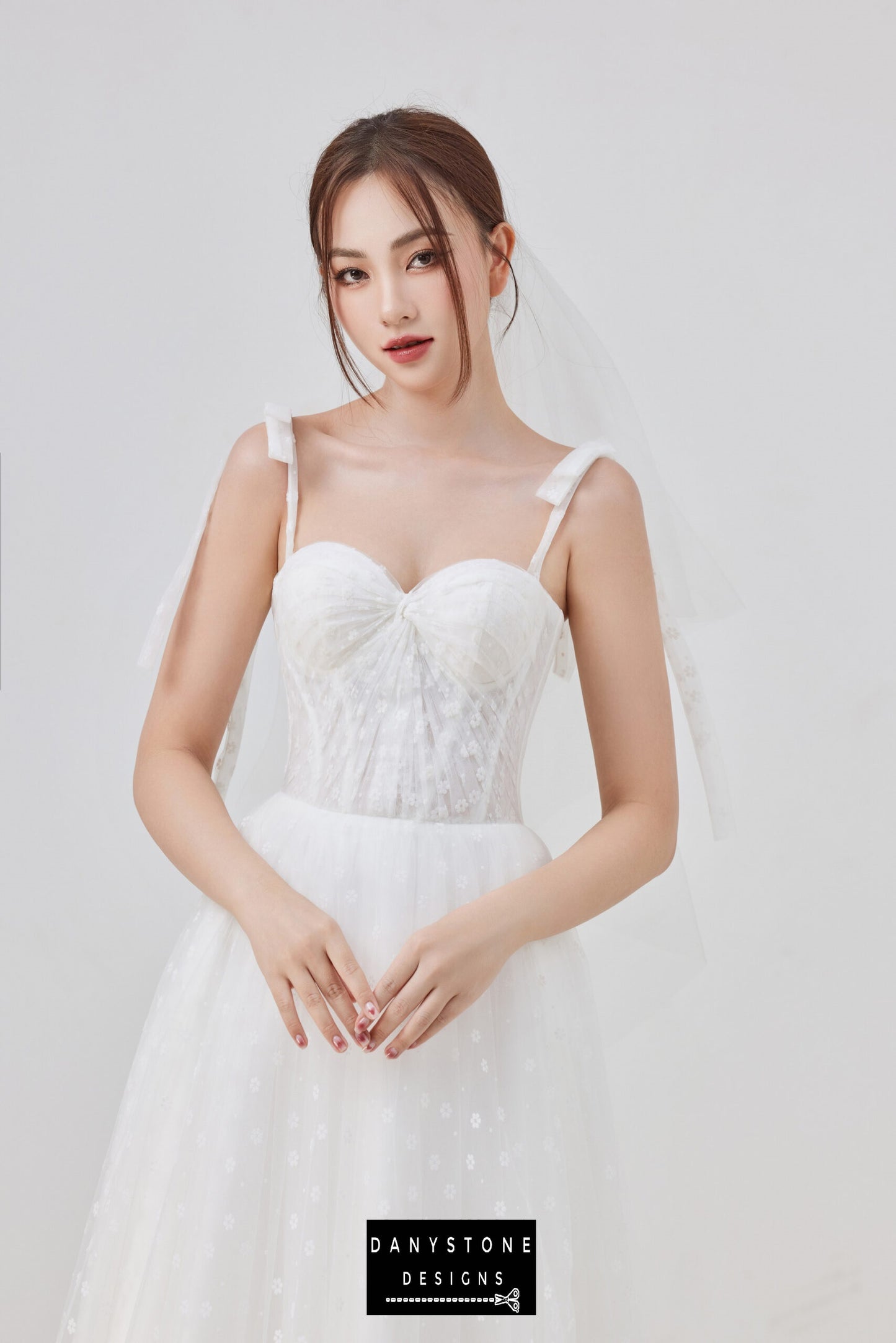 Elevate your bridal look with this exquisite tulle wedding dress. The gown showcases a structured corset bodice, sweetheart neckline, and charming bow straps for a timeless and sophisticated look.