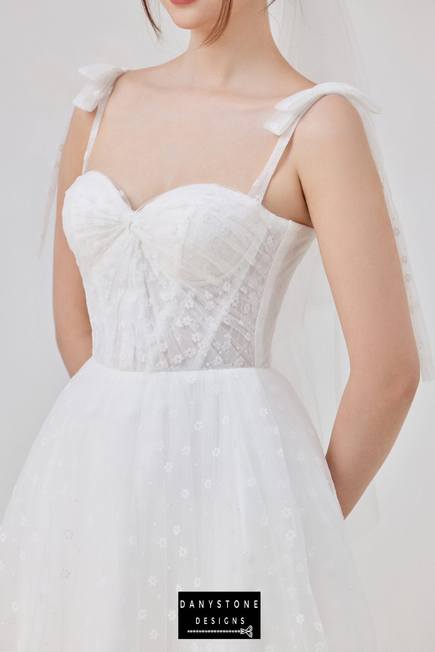 A close-up of the tulle corset wedding dress, showcasing the intricate lace details on the bodice and the charming bow straps. Ideal for brides seeking elegance and sophistication.