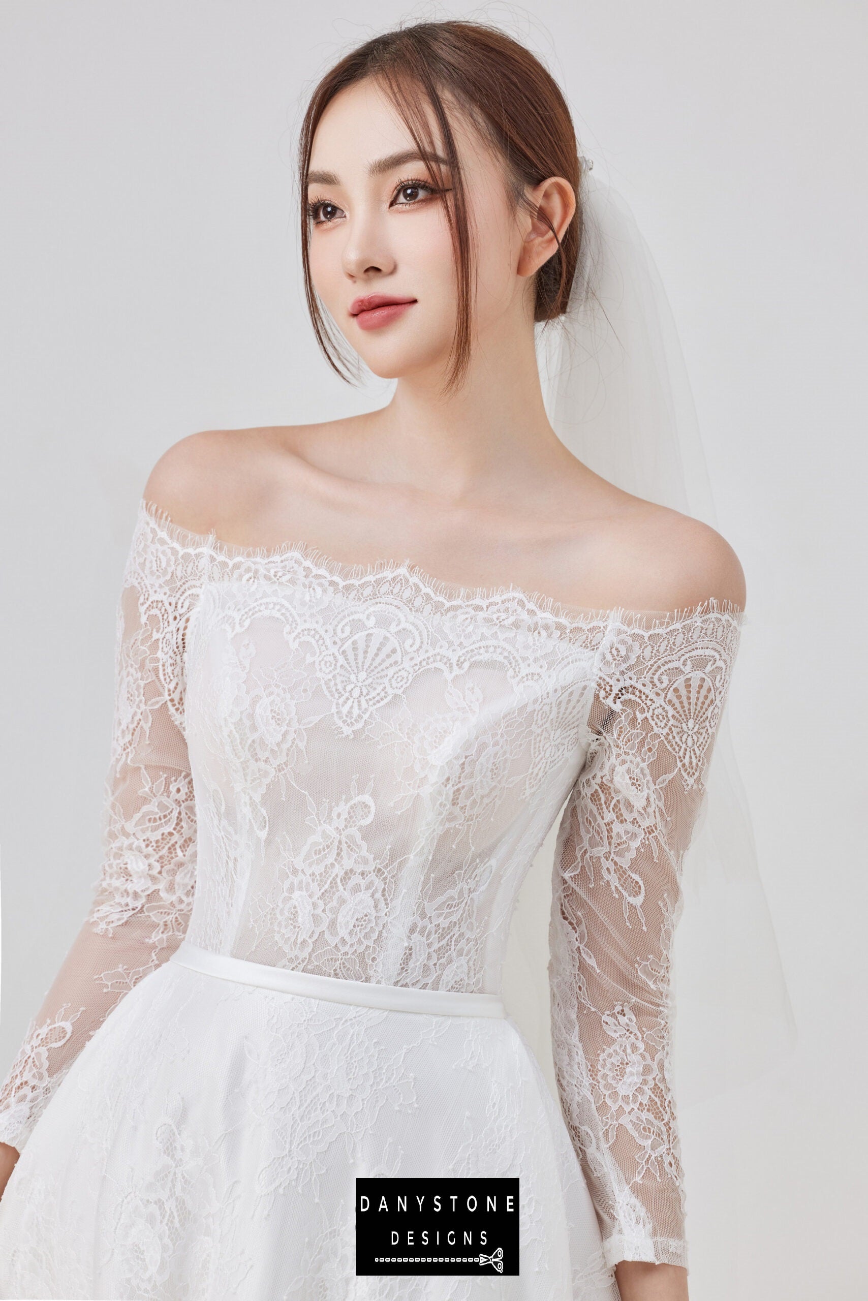 A close-up view of the thin lace dress with an off-shoulder neckline.