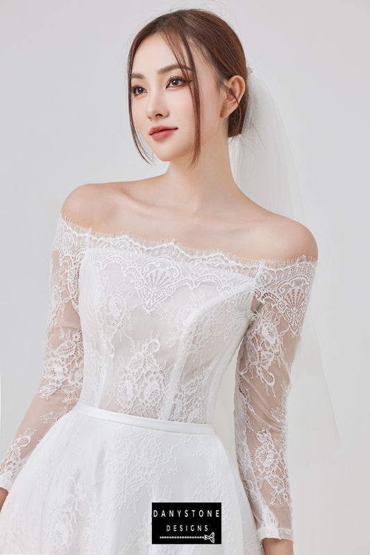 A close-up view of the thin lace dress with an off-shoulder neckline.