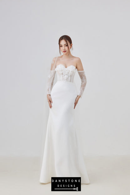 Full-length view of the model wearing a strapless wedding dress with 3D flowers and lace sleeves.