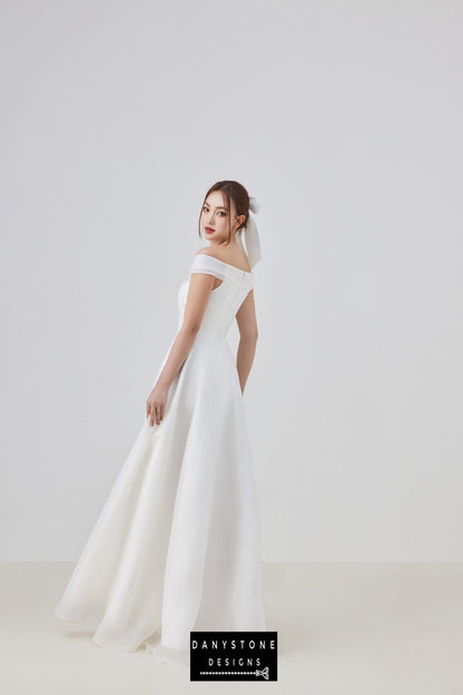 Close-up of off-shoulder wedding gown with large bow detail and elegant design