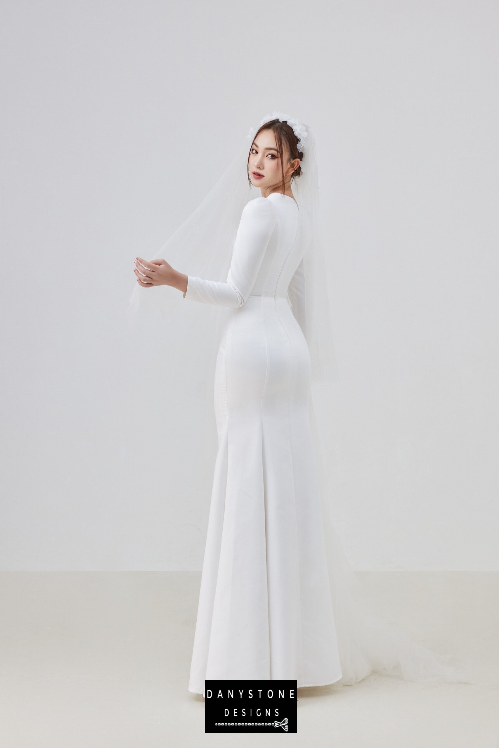 Bride in long-sleeve wedding gown with square neckline and fitted silhouette – Danystone Designs