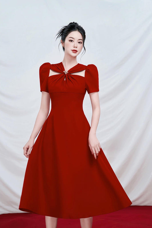 Woman wearing a red dress with a bow detail on a white background