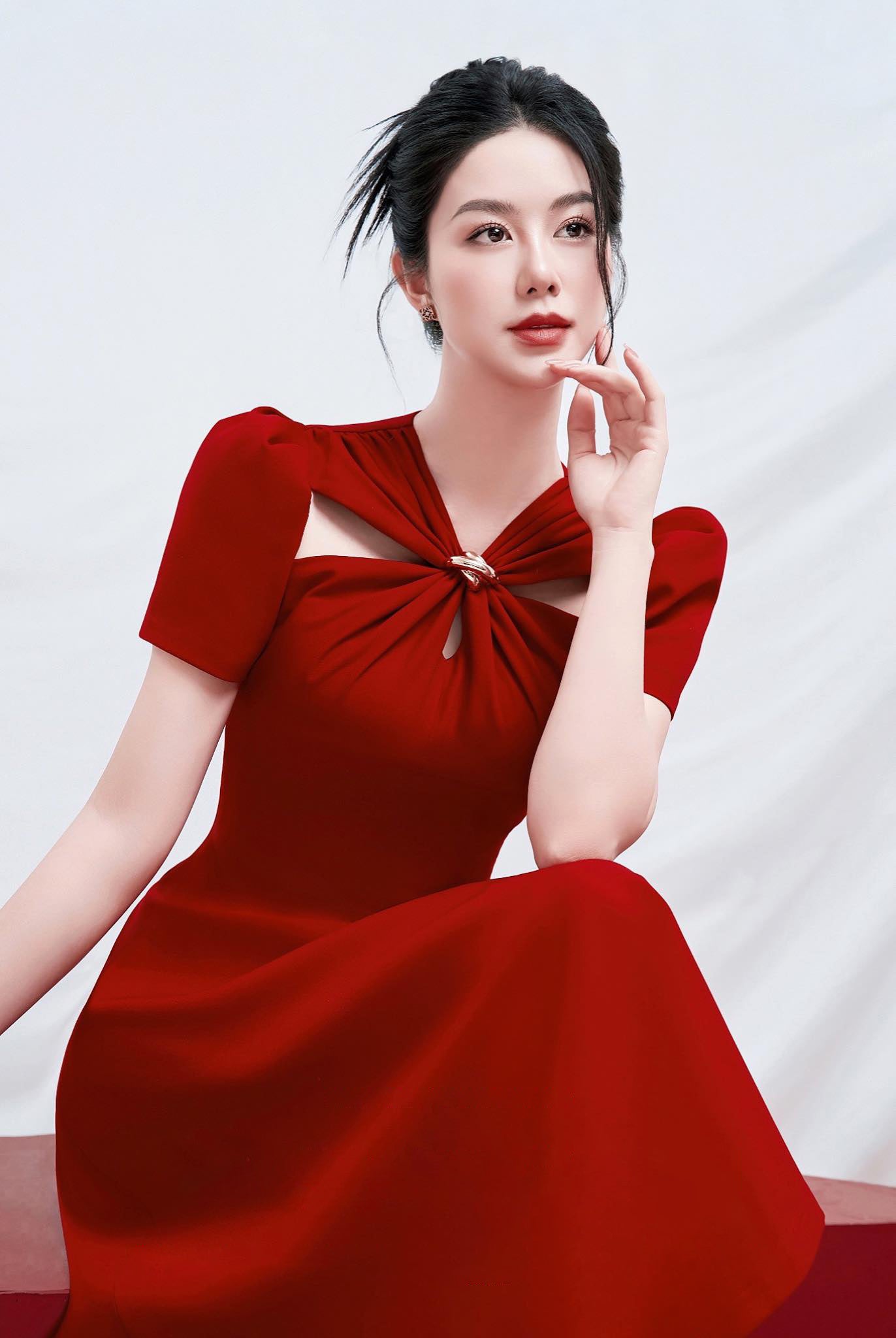 Woman wearing a red dress with a white background